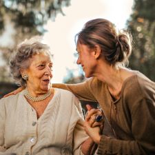 Image of a caregiver helping an elderly woman