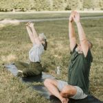 Man and woman outside doing yoga