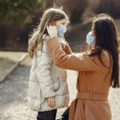 Woman preparing a child with a mask